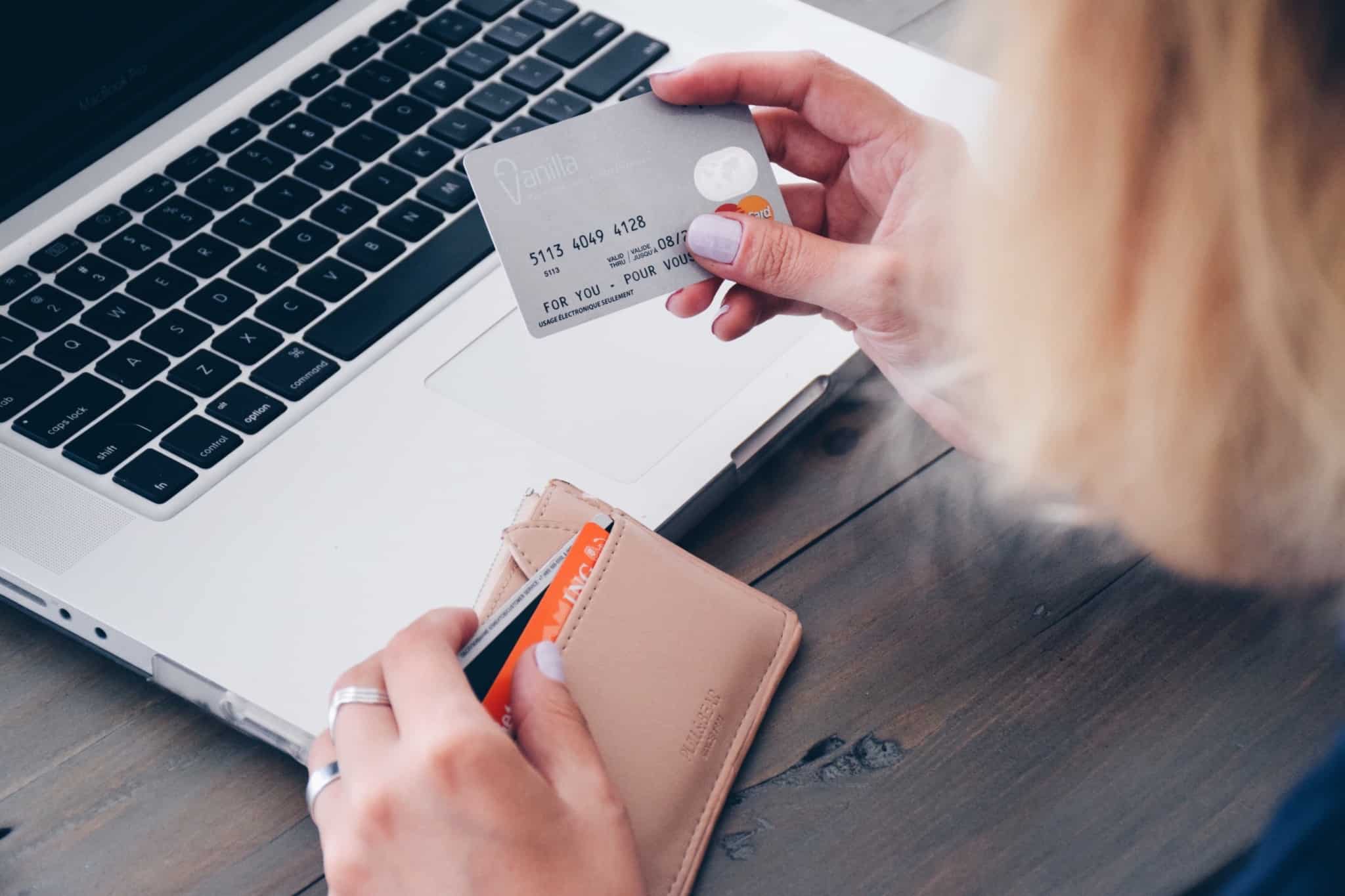 rapariga a fazer compras online com o cartao visa na mao e a carteira