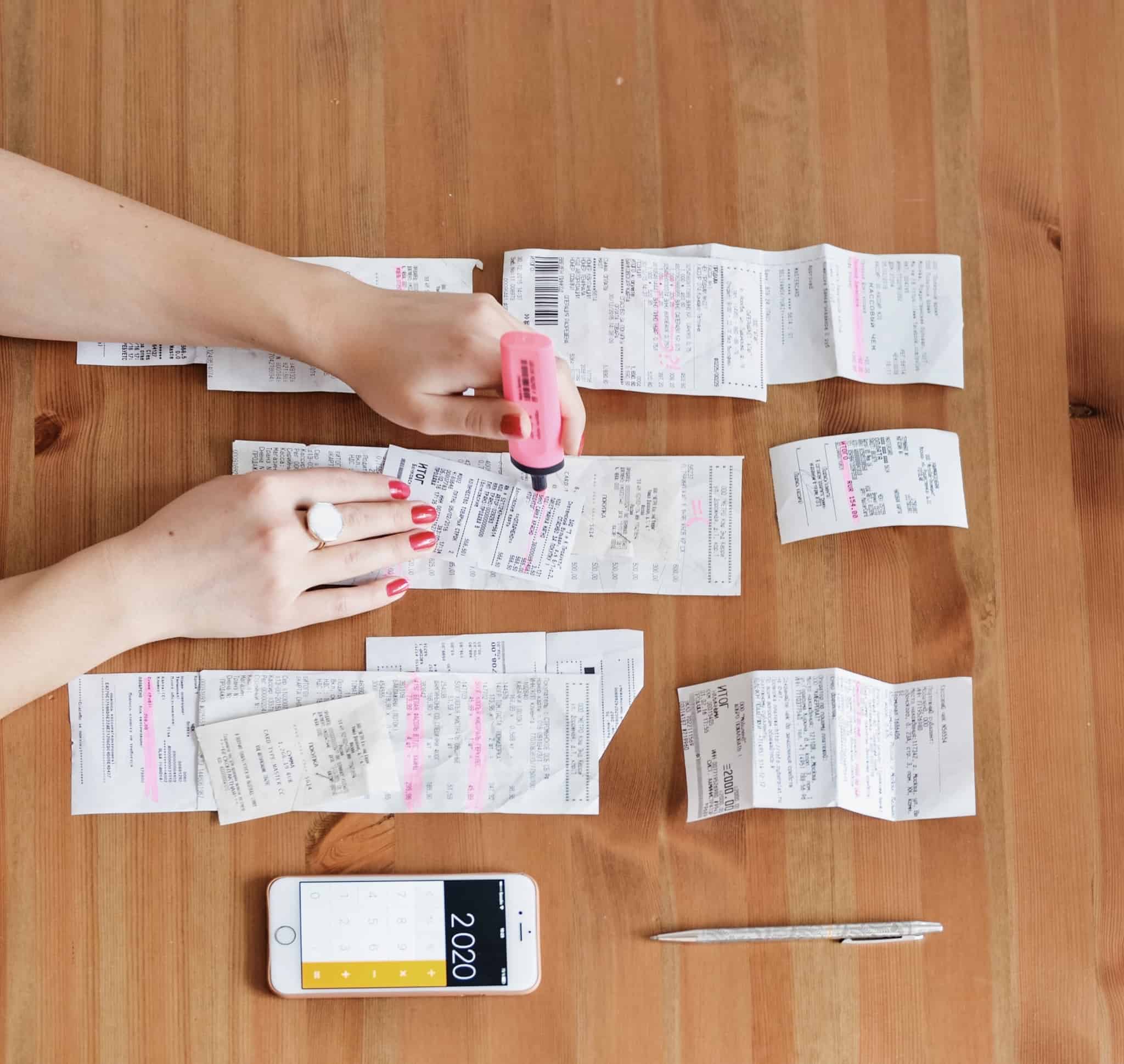 mão feminina a reunir faturas e a fazer contas