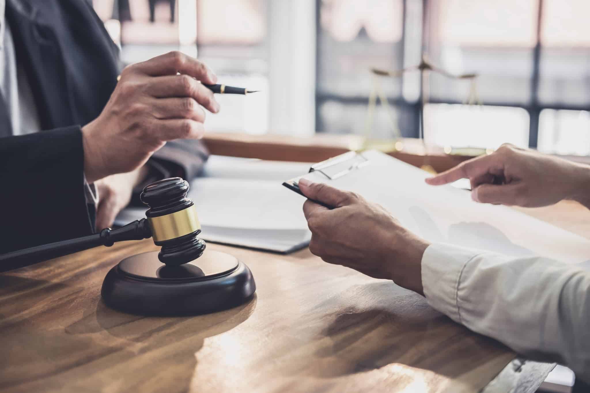 duas pessoas a conversar com o martelo na justiça