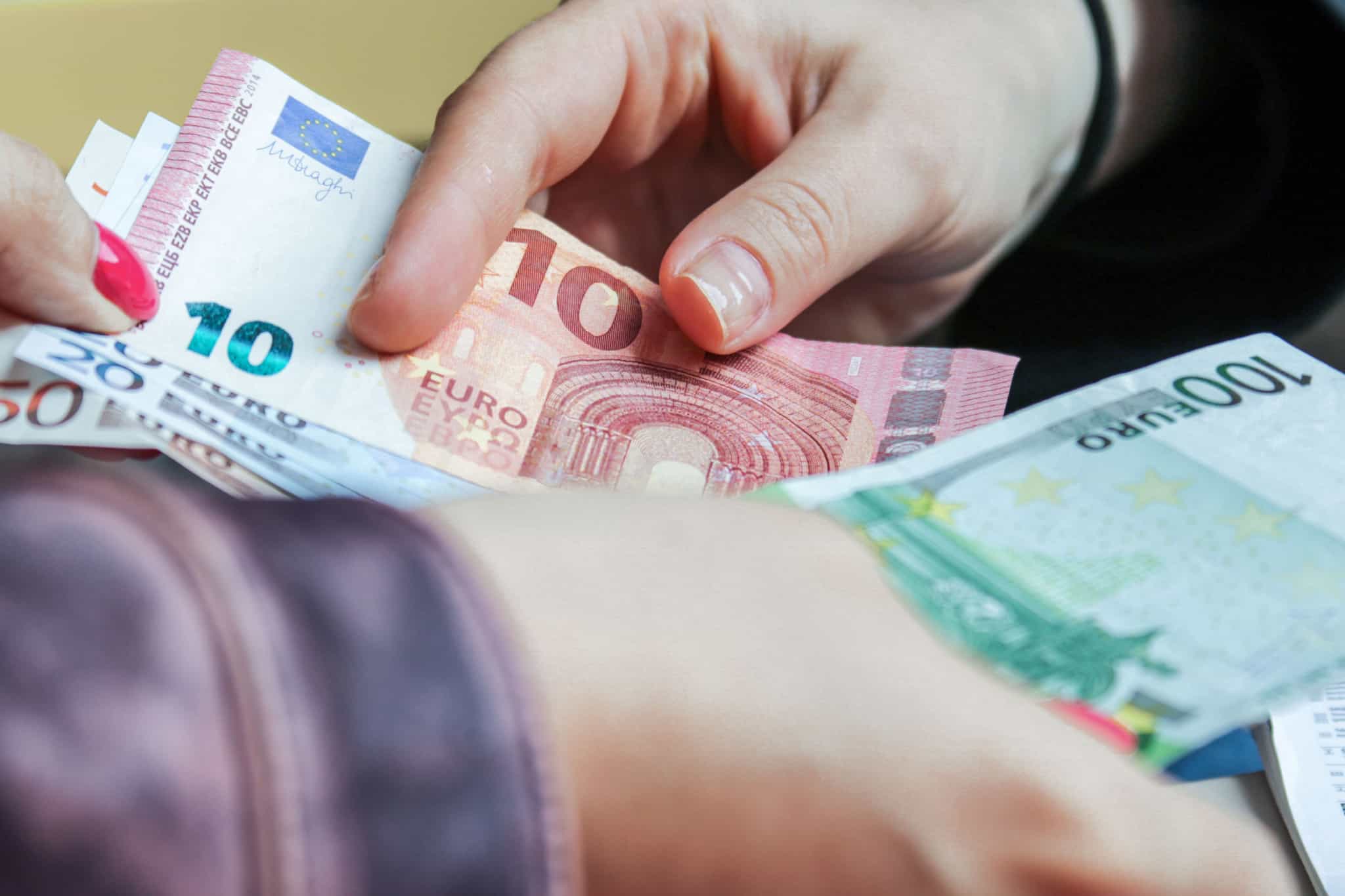 pessoas trocam notas de euro