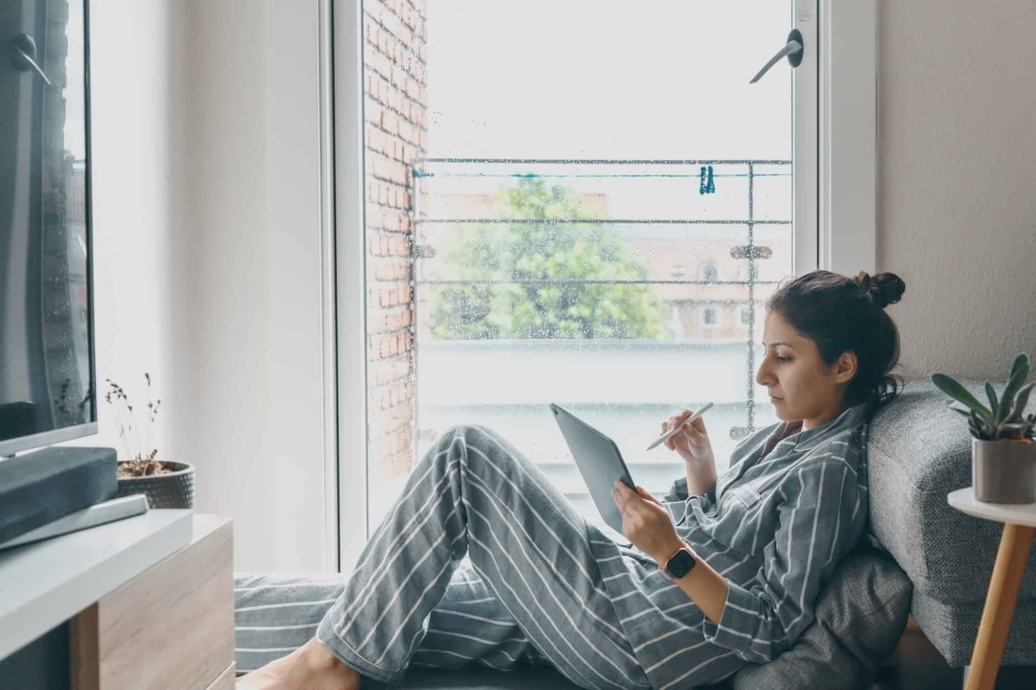 rapariga freelancer deitada a trabalhar a partir de casa