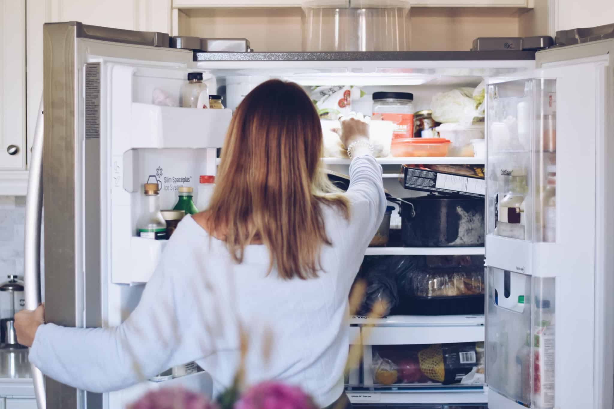 rapariga a retirar comida do frigorífico