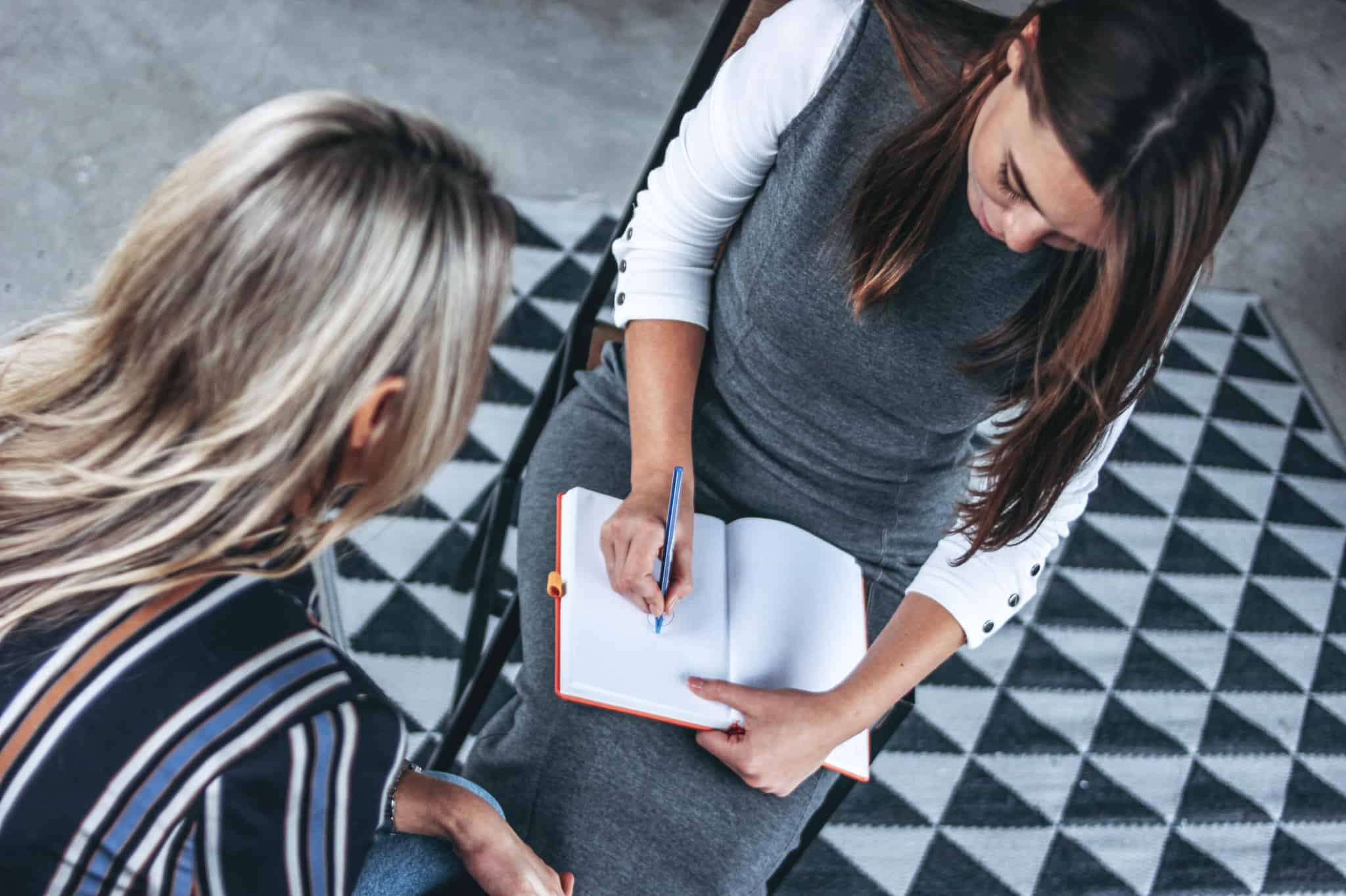 mulher a tirar apontamentos num caderno
