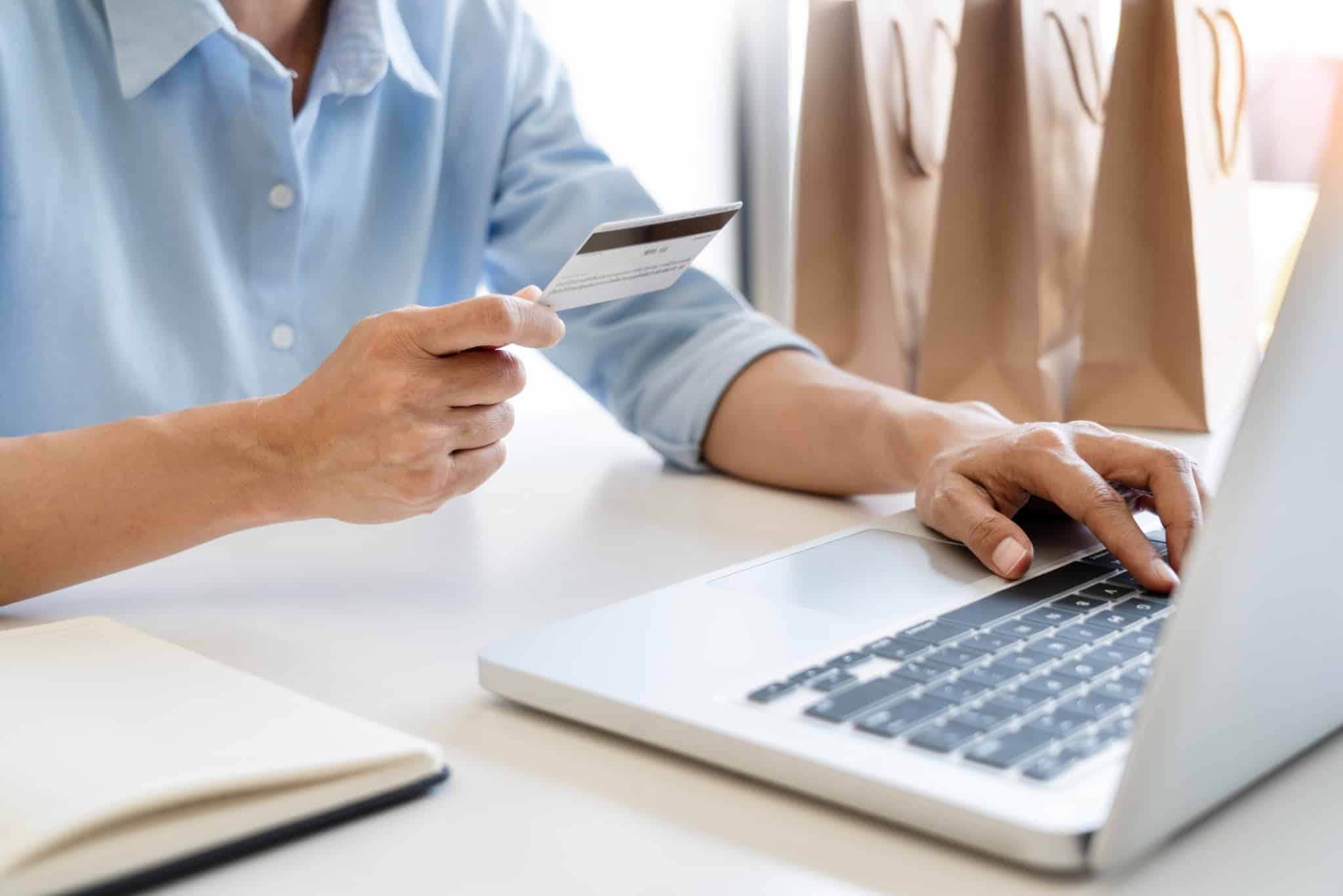 homem a fazer compras online a utilizar um cartao branco