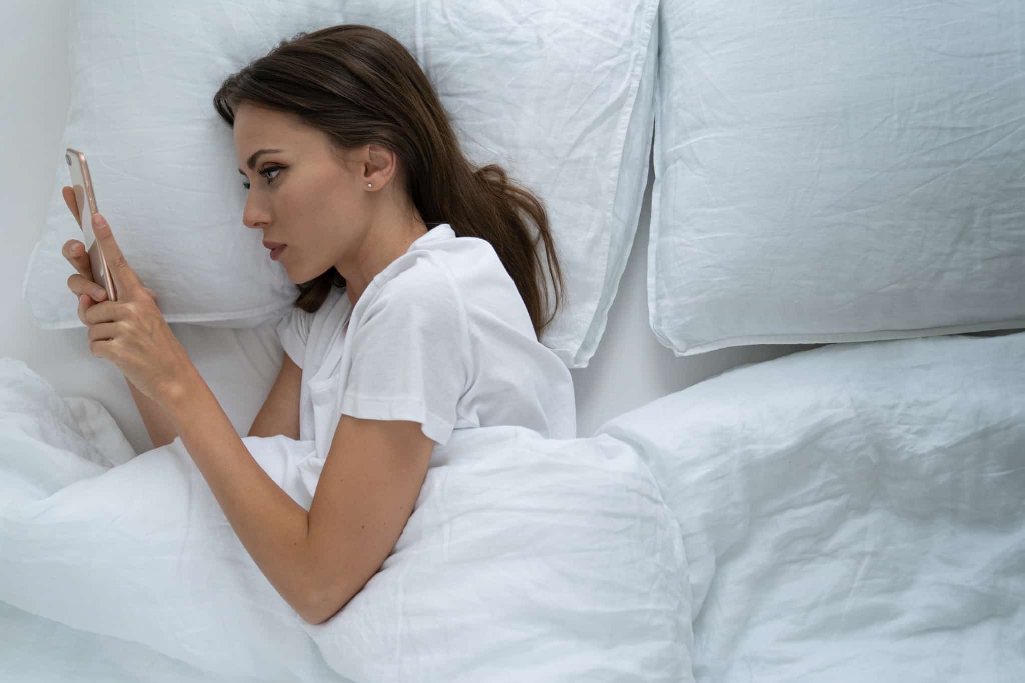 mulher na cama a mexer no telemóvel