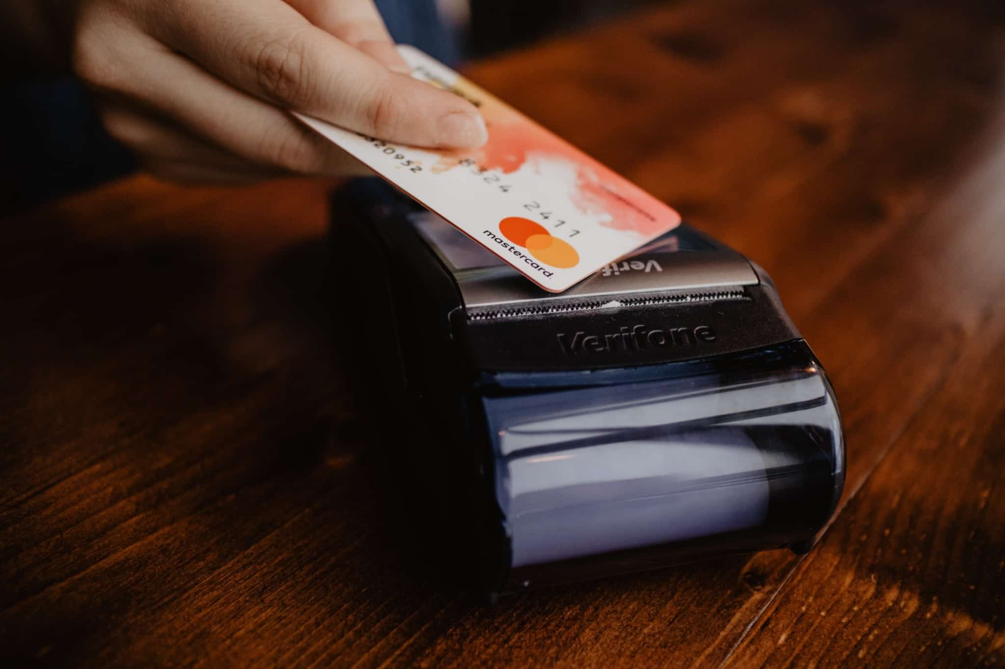 Mão com um cartão bancário a falhar no pagamento a ilustrar as contas bancárias congeladas
