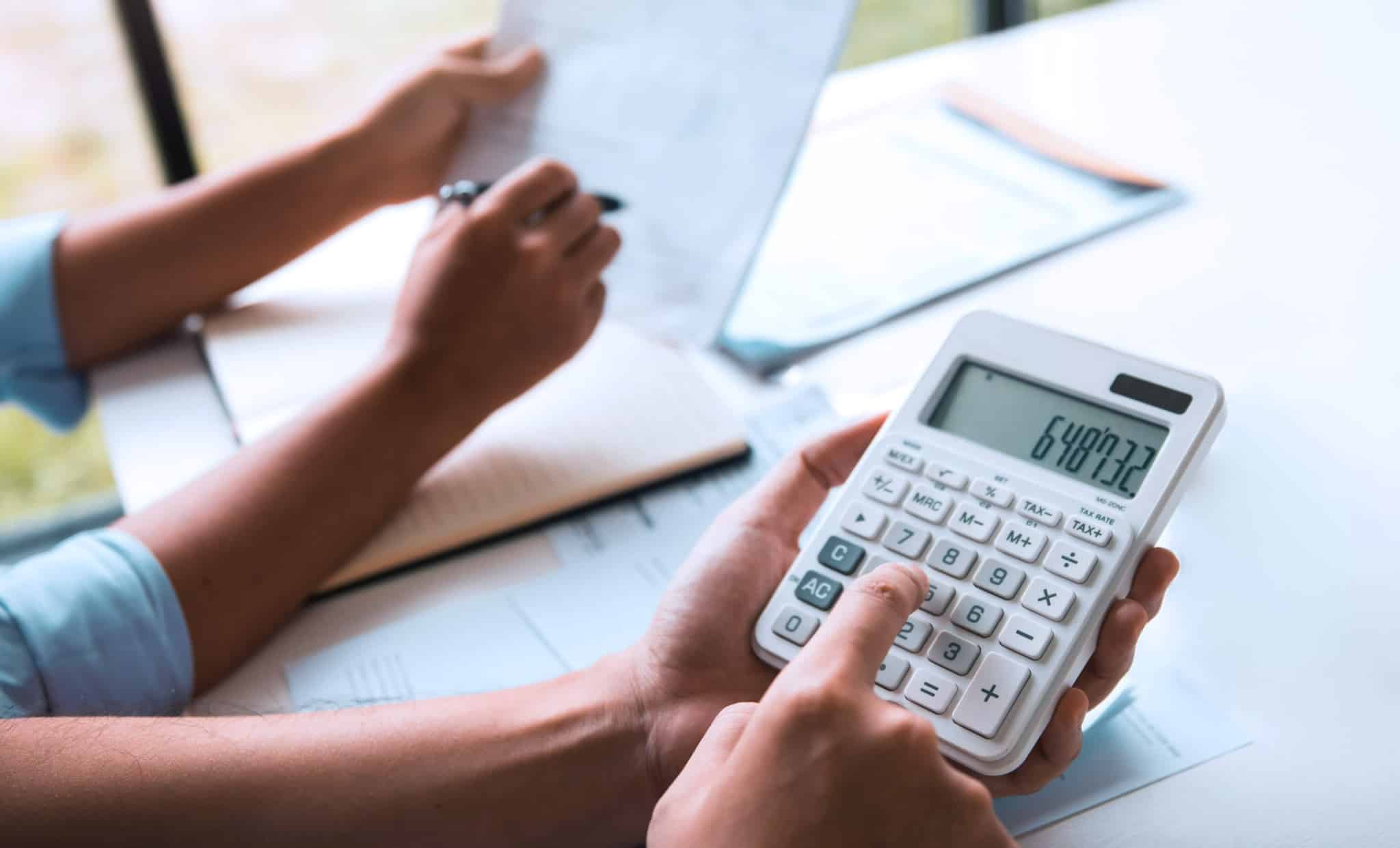 família a fazer contas na calculadora aos encargos do crédito pessoal