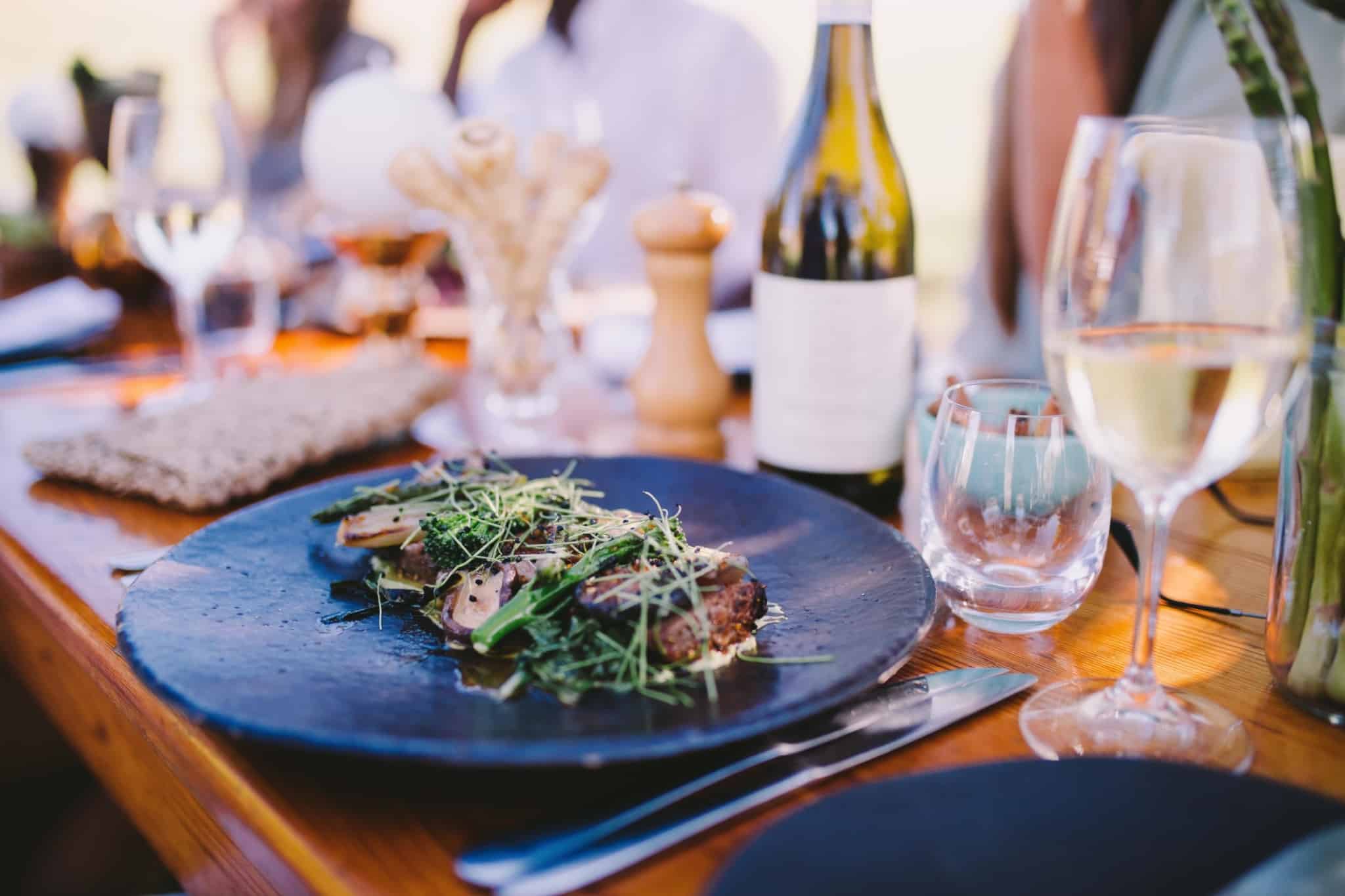 mesa num restaurante com copos de vinho e um prato com uma salada