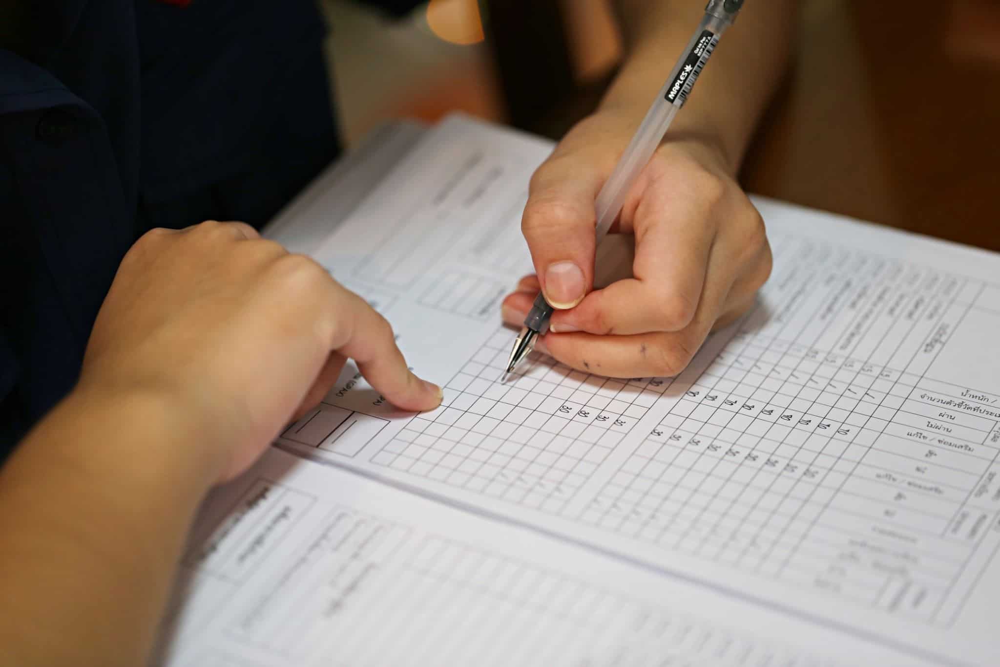 Mão preenche papel para declaração do IVA