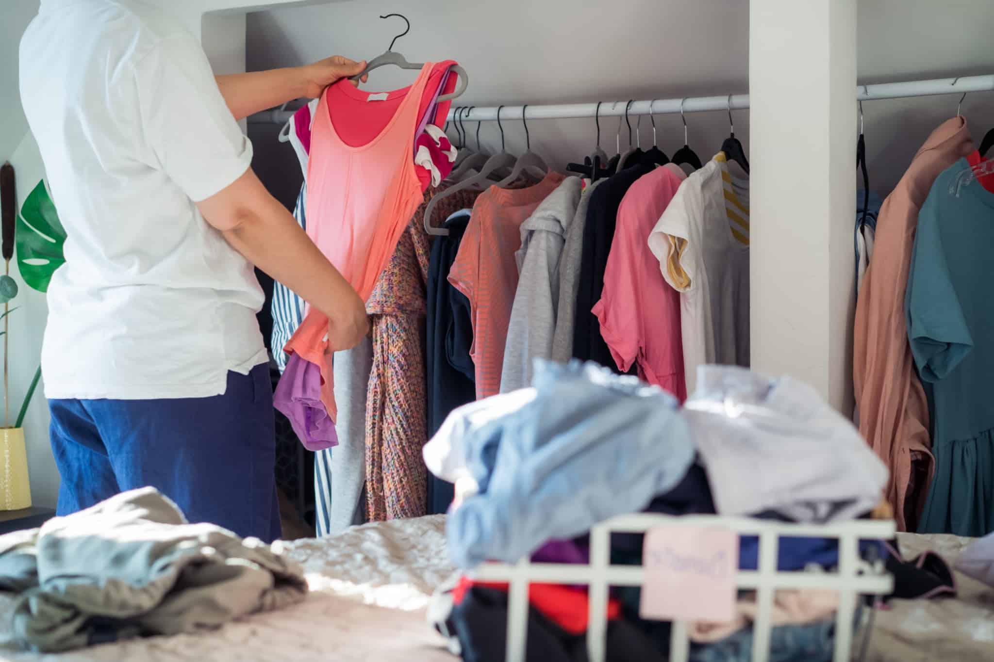 Jovem mulher a arrumar a roupa após ter descoberto 9 sites para comprar roupa barata