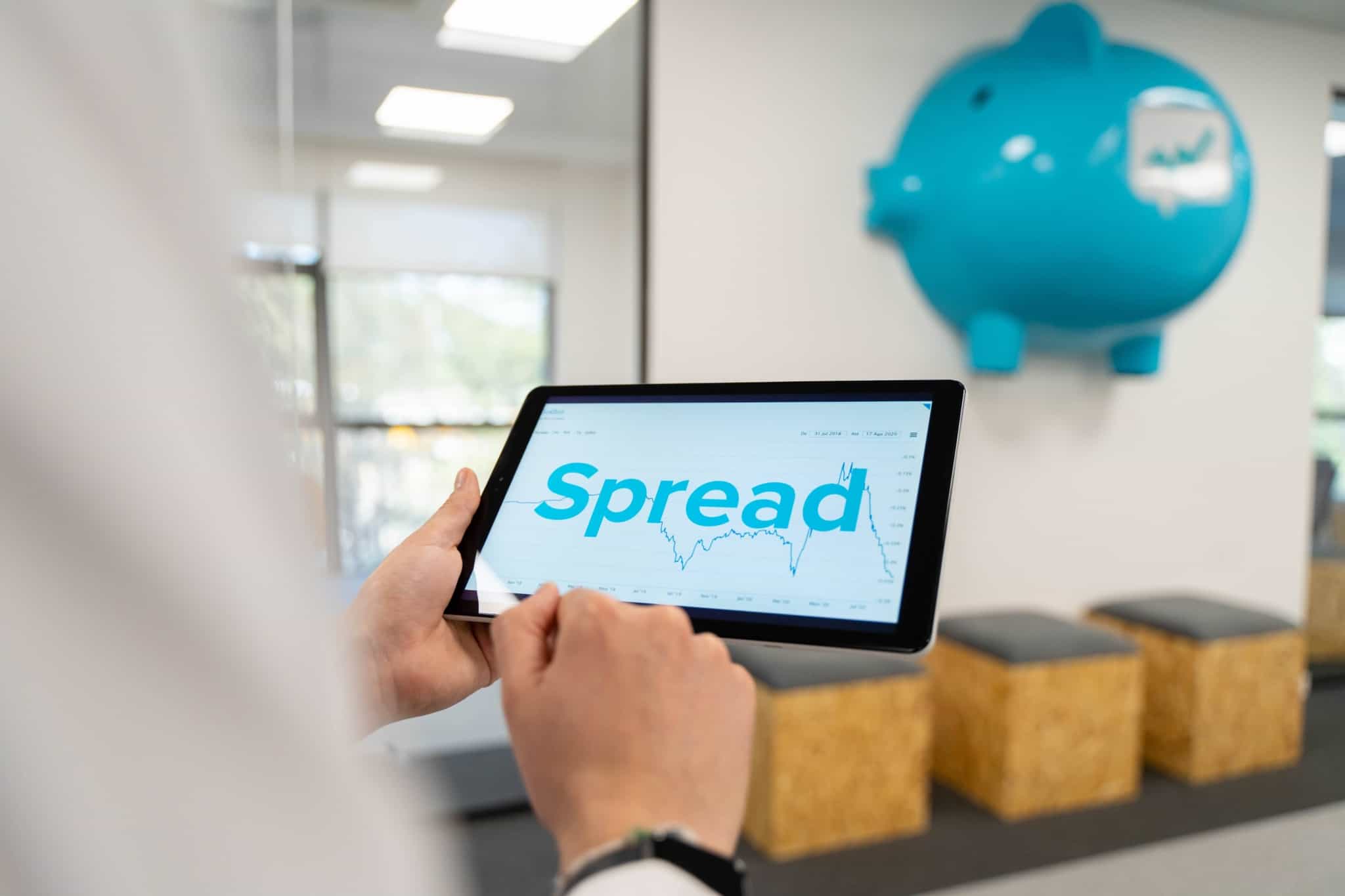 Homem consulta o tablet onde vê um gráfico de spreads no crédito habitação