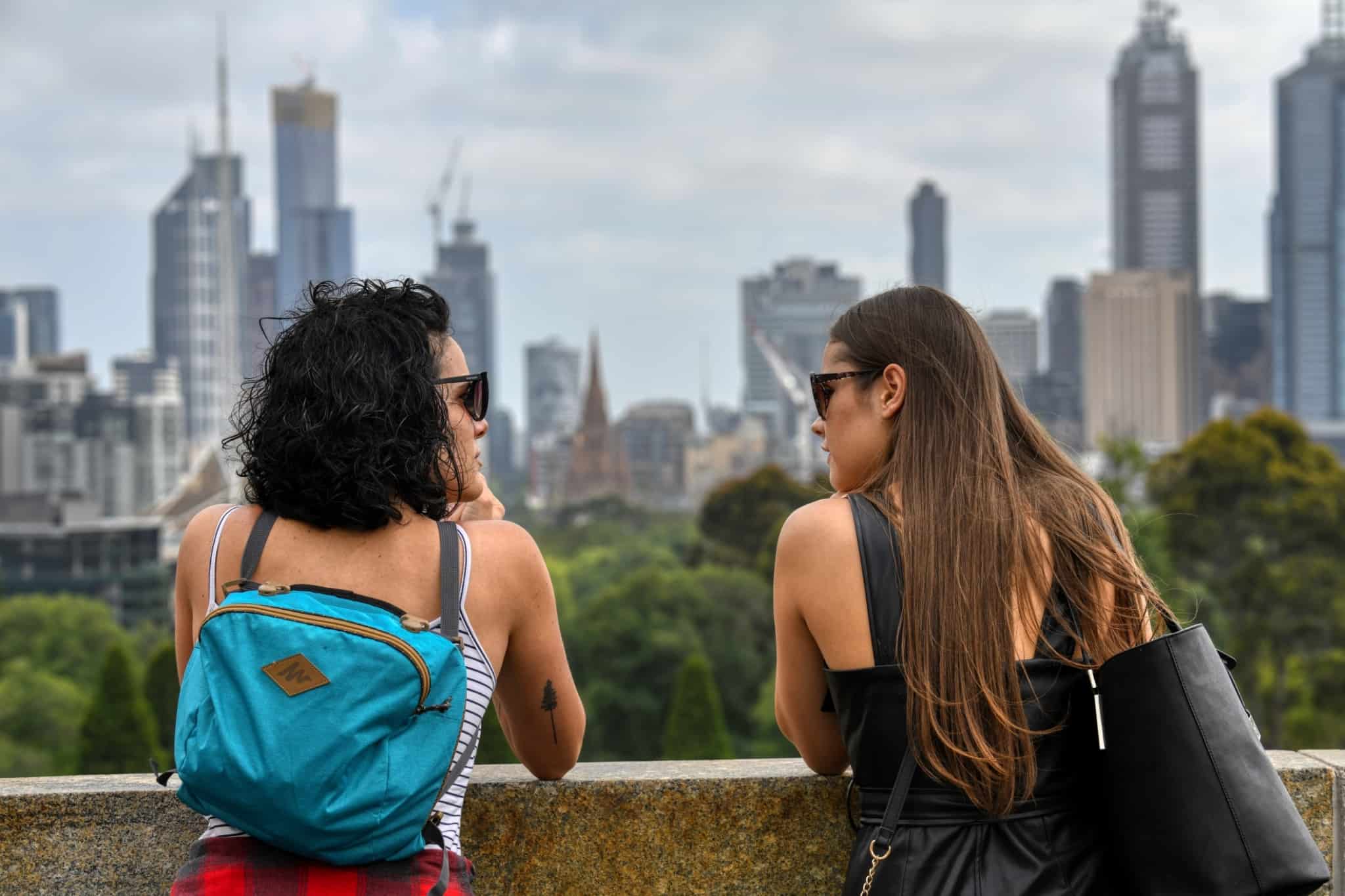 dias jovens à conversa, a apreciar a vista para a grande cidade, de mochilas às costas a usufruir de férias low cost