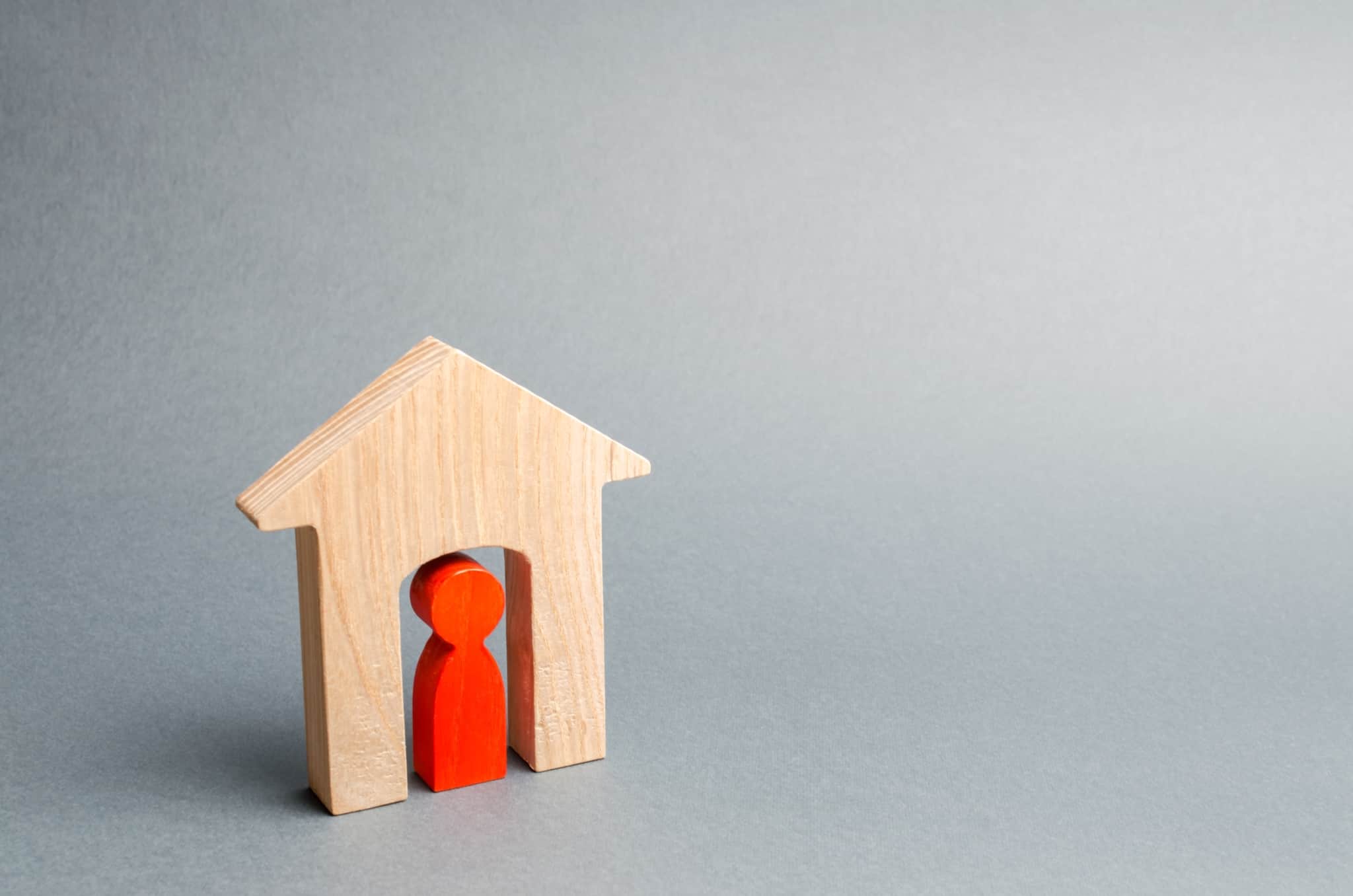 produção fotográfica com uma fachada de uma casa em madeira e um peão de madeira à porta, apenas com um fundo cinzento vazio, ilustram a carga negativa de um pedido de crédito habitação reprovado