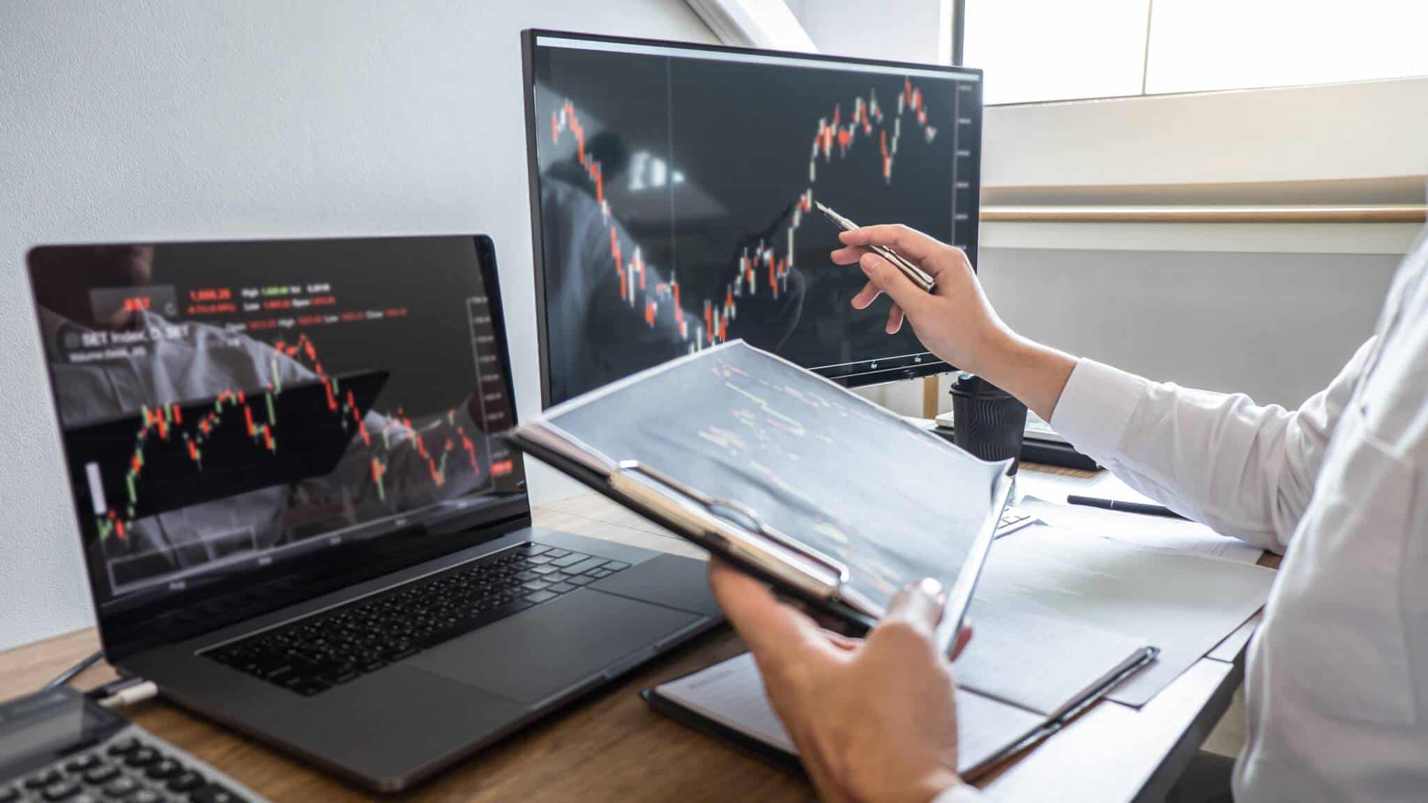 investidor a analisar a evolução do mercado acionista no ecrã do computador
