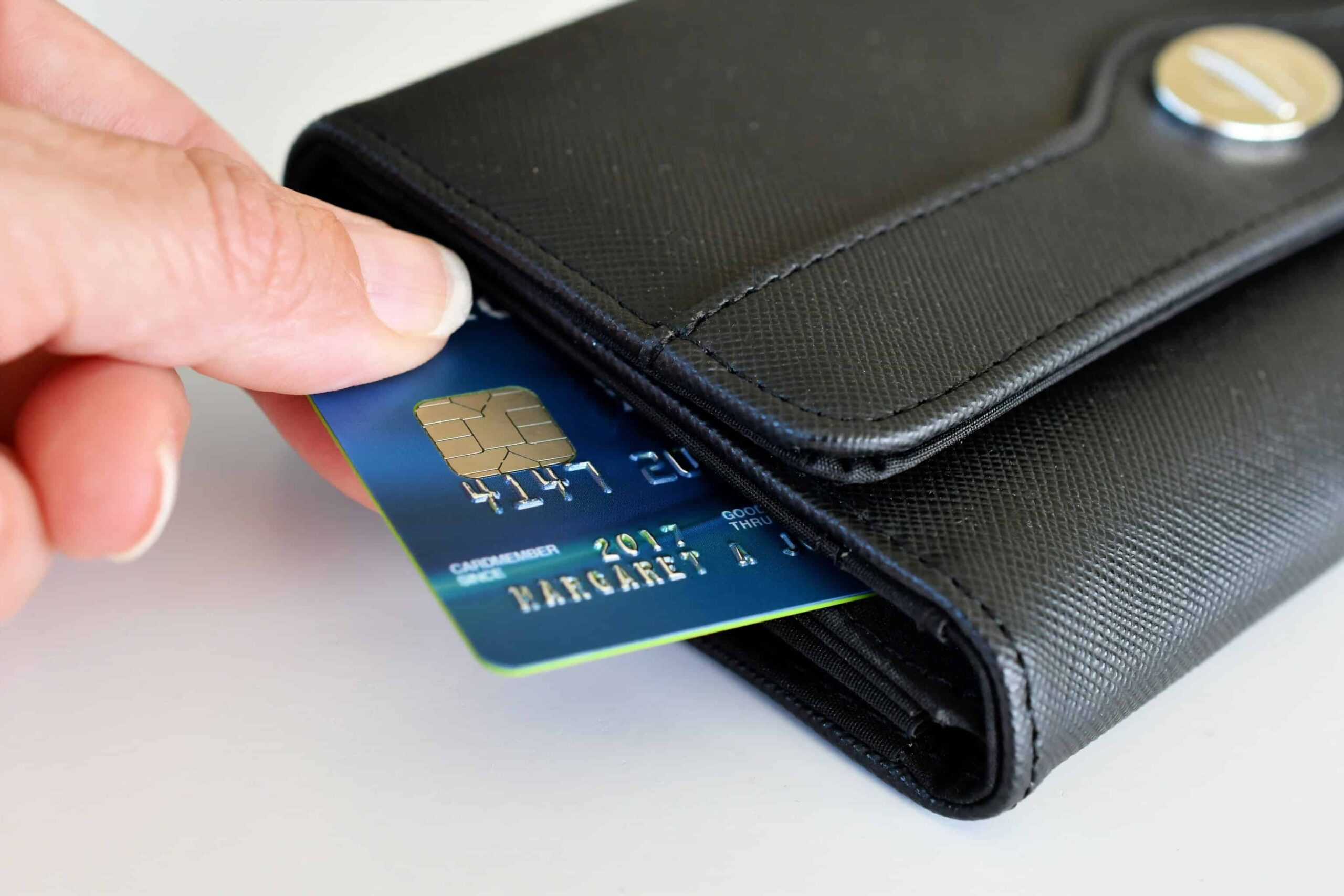mão retira de uma carteira um dos seus cartões de crédito