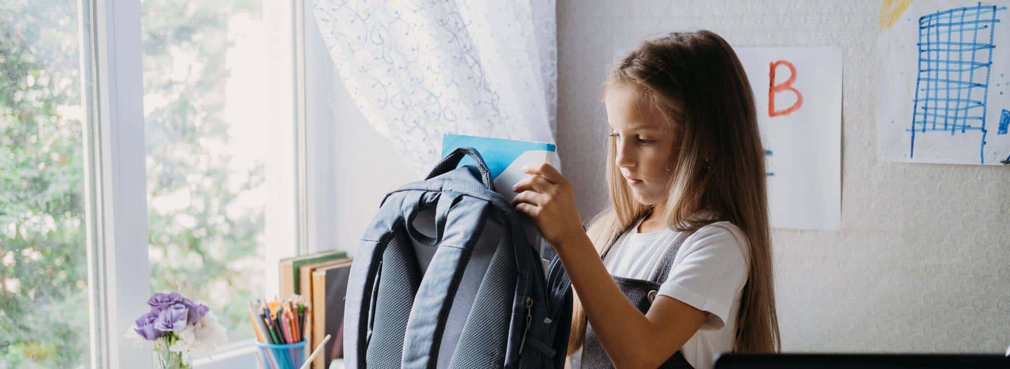 rapariga no quarto a preparar a mochila para as aulas