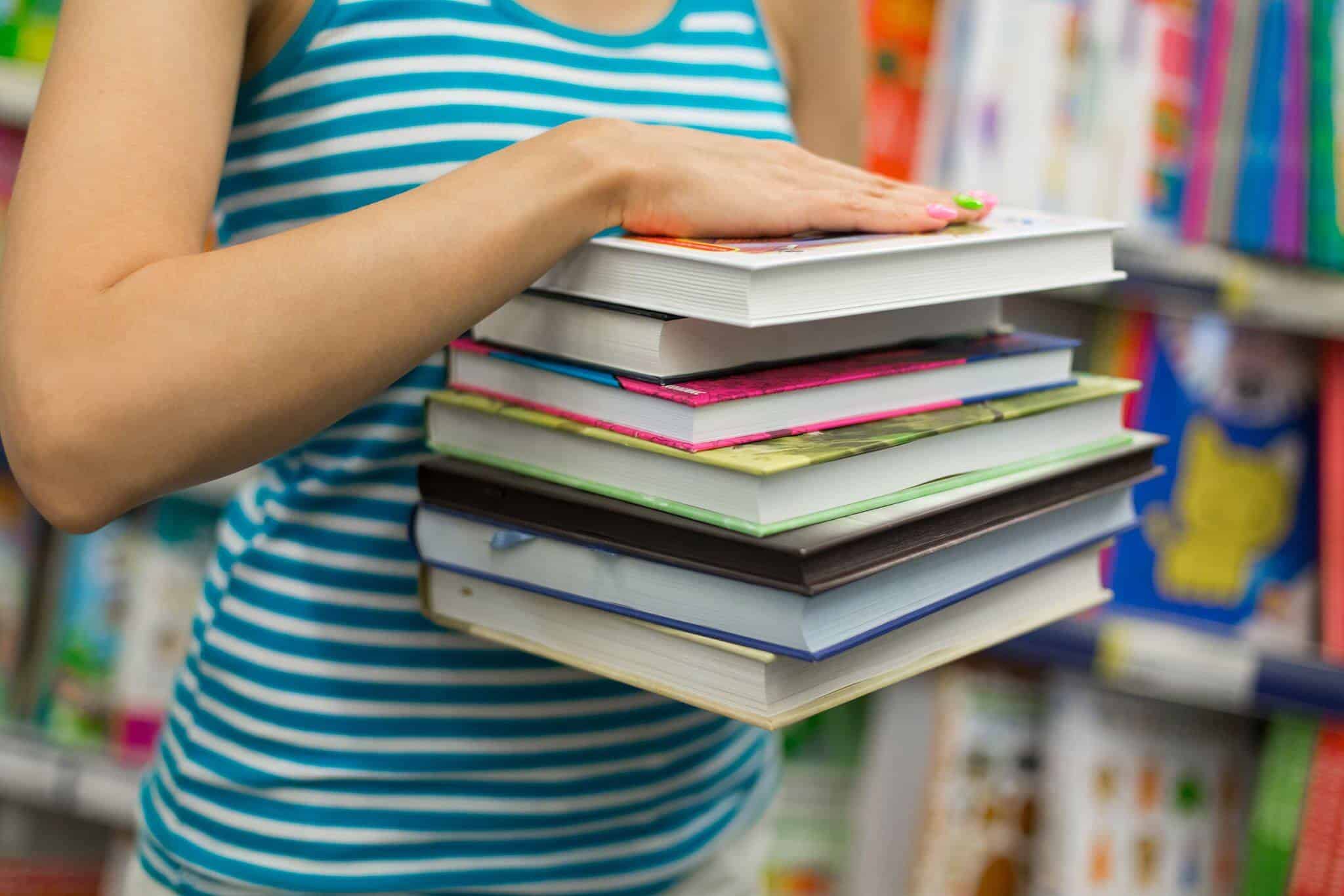 rapariga com manuais escolares na mão