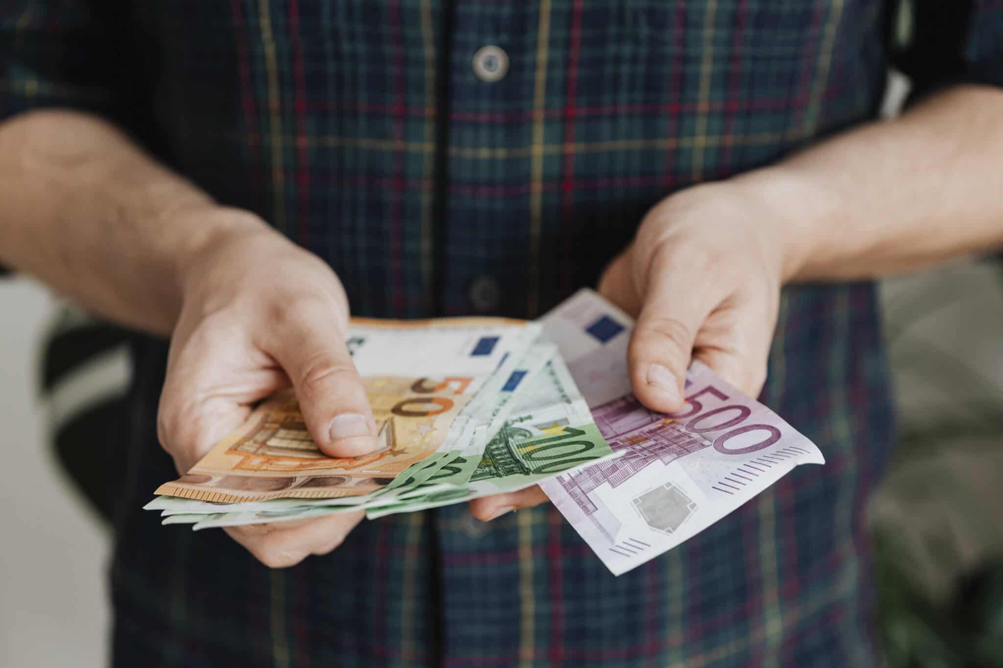 homem a contar notas a ilustrar o aumento das prestações sociais em 2024