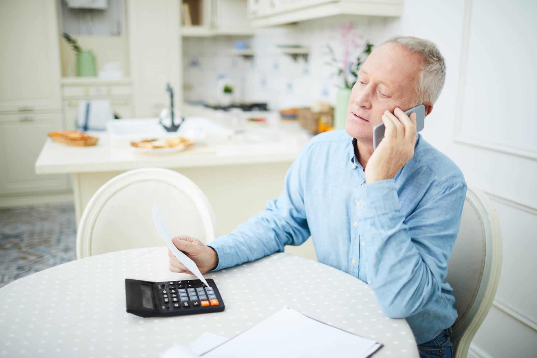 Tabelas de IRS para pensionistas (2.º semestre de 2023) homem a fazer contas na calculadora