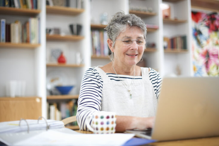 idosa frente ao computador a verificar se tem direito ao complemento solidário para idosos
