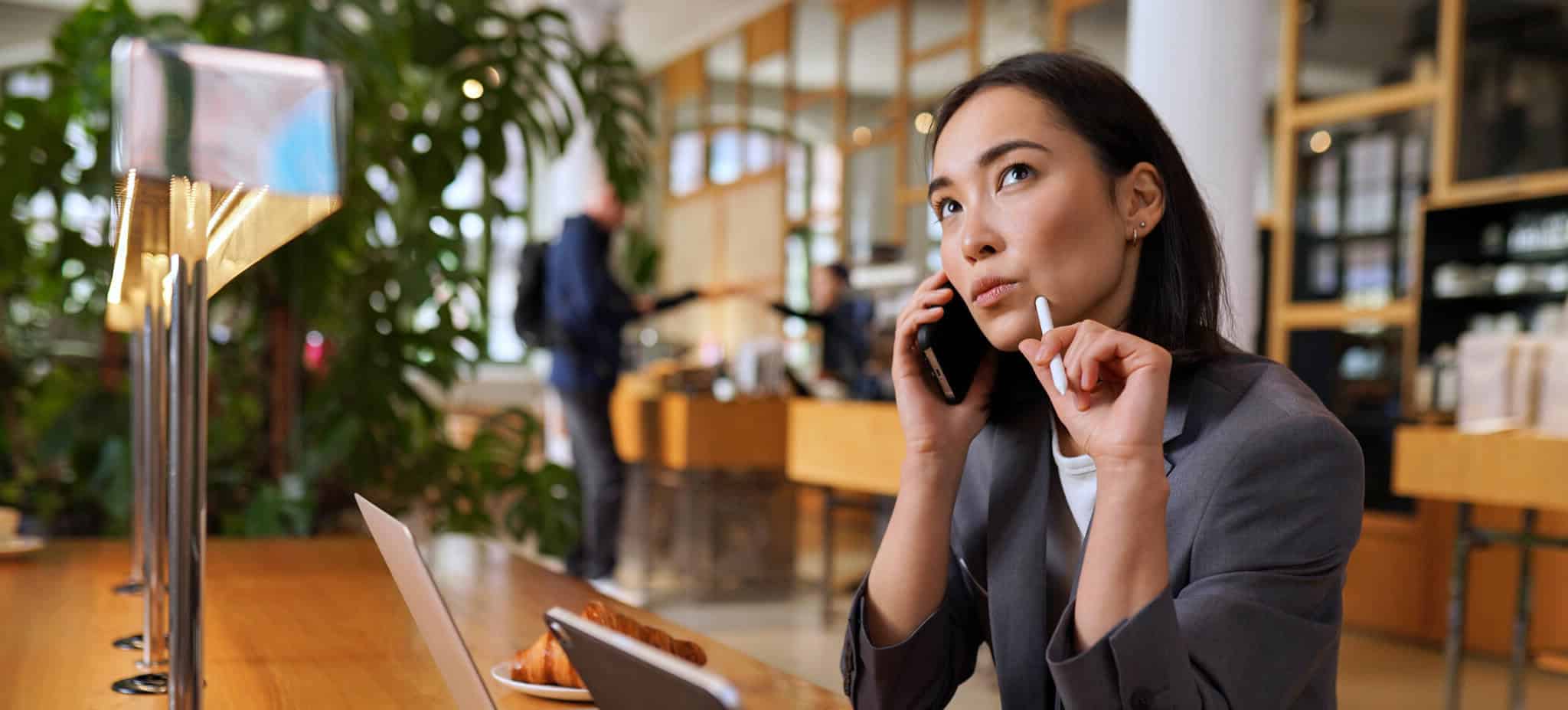 Mulher ao telefone com ar pensativo